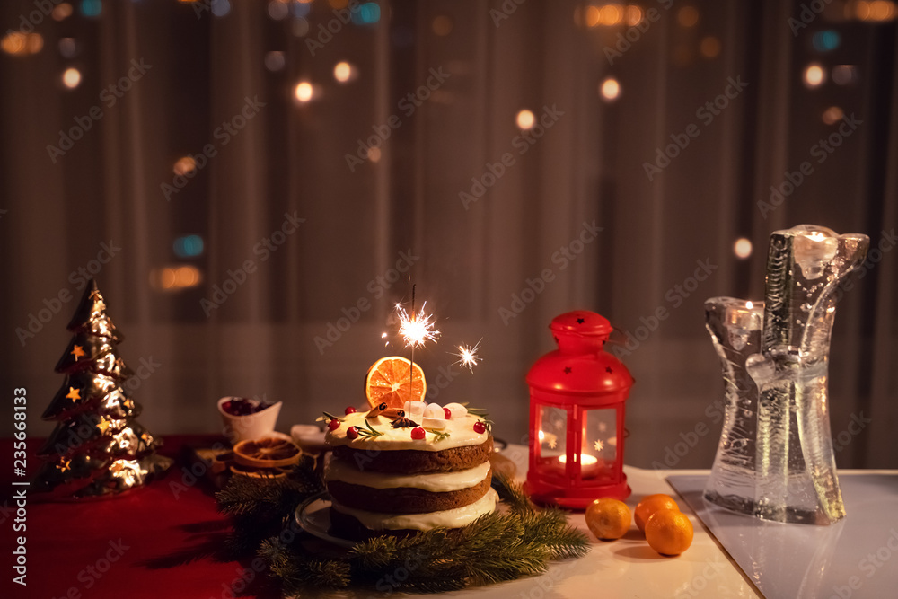 A Sparkler in the cake at night at Christmas time A Sparkler in the cake at night at Christmas time
