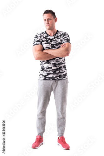 Frustrated adult distrustful man with crossed arms looking at camera. Full body isolated on white background. 