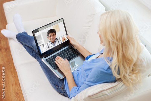 medicine, technology and healthcare concept - woman or patient having video call with male doctor on laptop computer at home