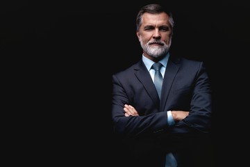 Handsome mature business man isolated on black background
