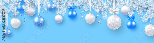Blue Christmas and New Year banner with white fir branches and shiny Christmas balls.