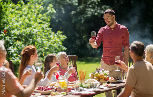 leisure  holidays and people concept - happy family having festive dinner or summer garden party and celebrating