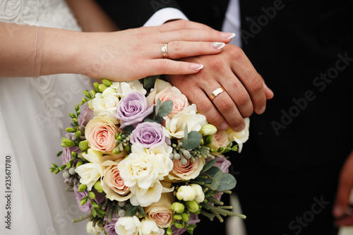 wedding bouquet in hands of bride and groom