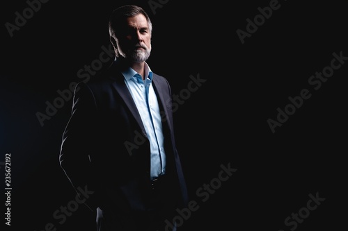 Handsome mature business man isolated on black background
