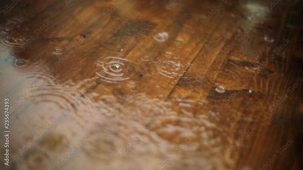Close up video of some rain drops falling on a wooden platform. Close up video of some rain drops falling on a wooden platform.
