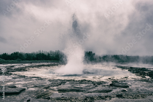 Magnificent Strokkur Geyser erupts the fountain of water, dramatic vintage image of popular tourist attraction, Haukadalur geothermal area, Iceland