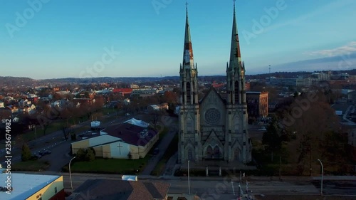 Aerial shot flying through the crumbling towers of an abandoned church in an urban city neighborhood