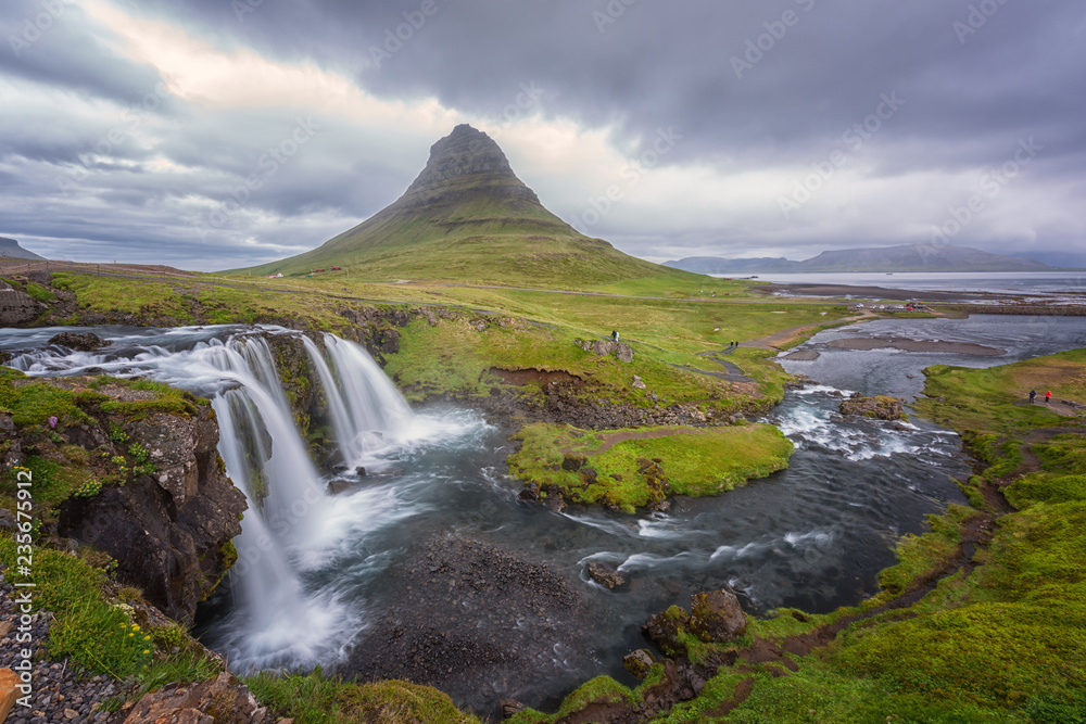 Famous Kirkjufellsfoss waterfall with Kirkjufell (church mountain) on the background, beautiful panoramic landscape, iconic view of the Snaefellsnes peninsula, Iceland