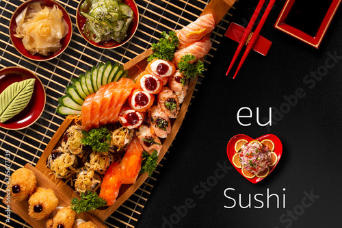 Japanese food combo in black background.itten I love Sushi in portuguese. Top view photo