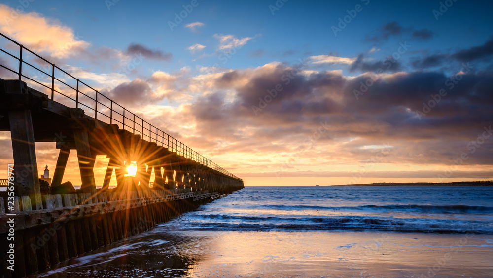 Sunburst on River Blyth Harbour West Pier, as the river reaches the North Sea between the piers in Northumberland