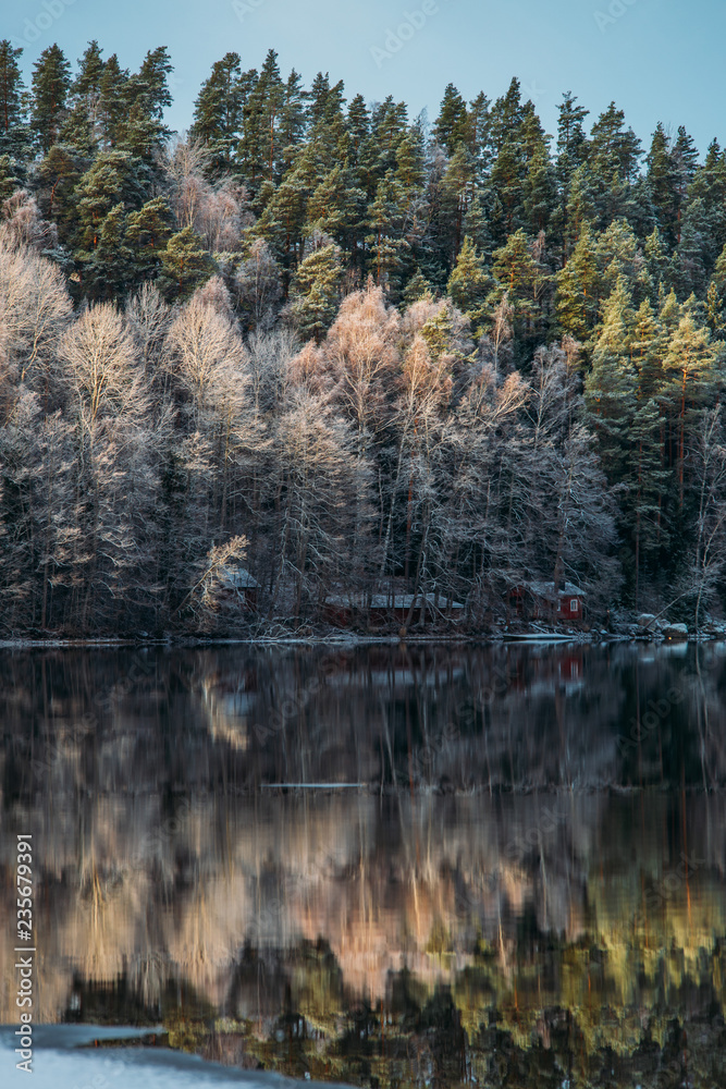 Incredible reflections in the lake with beautiful sunset light. The first frosts in Scandinavia, Finland