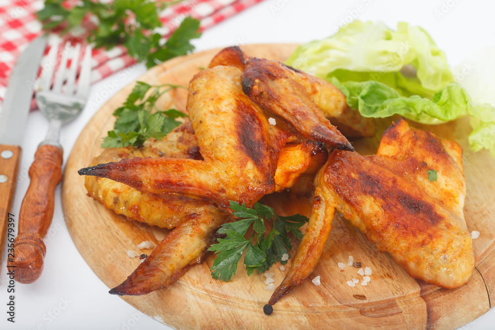 Golden crispy, roasted chicken wings on wooden board Golden crispy, roasted chicken wings on wooden board