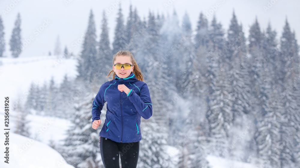Teenage girl running on winter mountain trail Teenage girl running on winter mountain trail