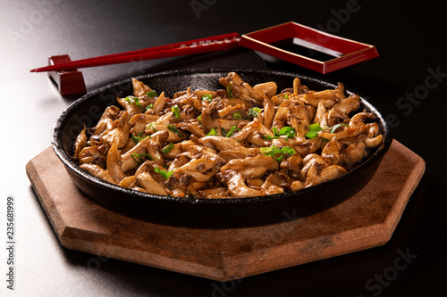 shimeji mushrooms in iron pan in a black background. photo