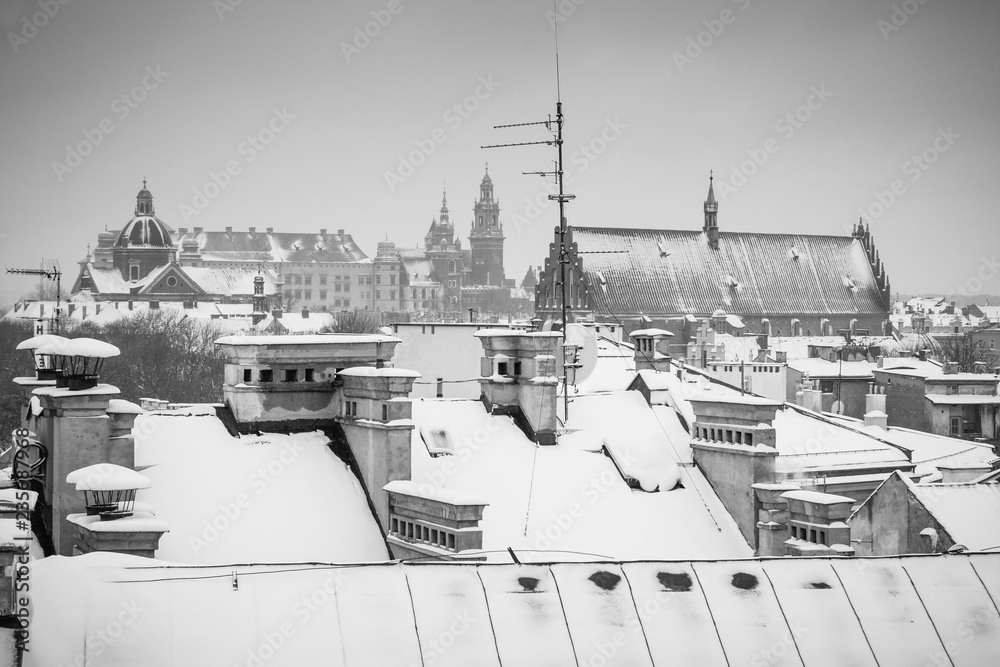 Fototapeta premium Krakow in Christmas time, aerial view on snowy roofs in central part of city. Wawel Castle and the Cathedral. BW photo. Poland. Europe.