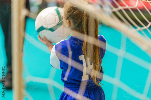 kids in blue teams train and play football in the hall. girls and boys play together soccer. photo