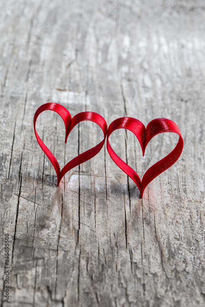Fototapeta premium Two ribbon hearts on wood