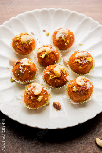 Carrot Halwa Laddu or sweet balls, served in a plate with dry fruits toppings. selective focus