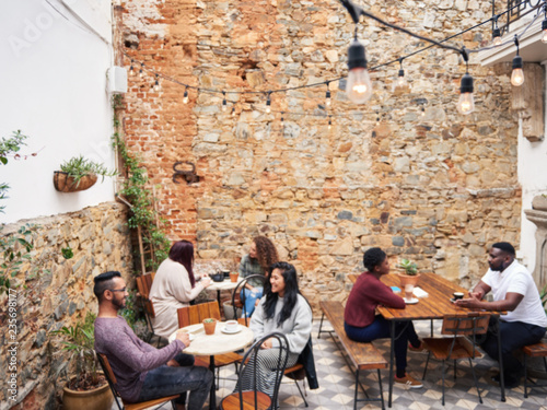 Diverse people talking together over coffee in a cafe courtyard