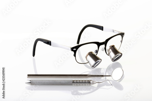 Dentist dental tools equipment on white background, loupes, surgical loupes, dental probe and mirror. Dental concept. Dentist Concept. Dental background.- Image photo