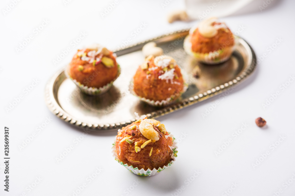 Carrot Halwa Laddu or sweet balls,  served in a plate with dry fruits toppings. selective focus