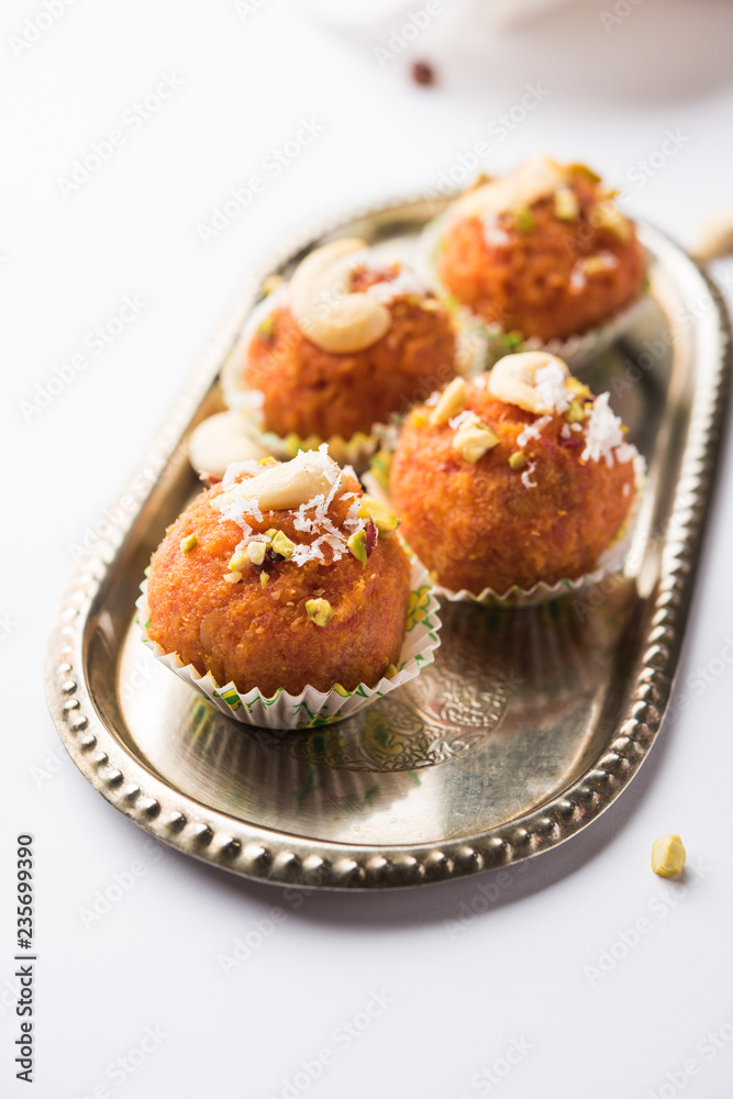 Carrot Halwa Laddu or sweet balls, served in a plate with dry fruits toppings. selective focus Carrot Halwa Laddu or sweet balls, served in a plate with dry fruits toppings. selective focus