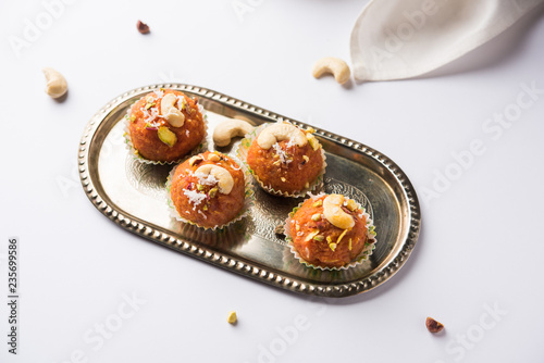 Carrot Halwa Laddu or sweet balls, served in a plate with dry fruits toppings. selective focus