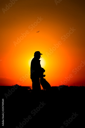 Silhouette old man at the seside at sunset in Izmir, Turkey.