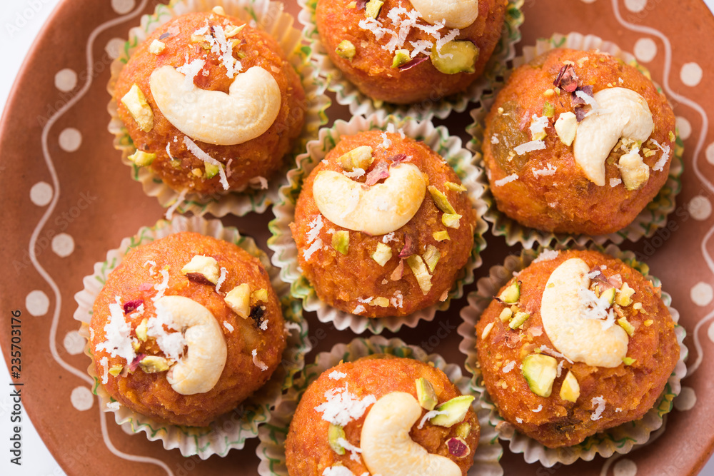 Carrot Halwa Laddu or sweet balls, served in a plate with dry fruits toppings. selective focus Carrot Halwa Laddu or sweet balls, served in a plate with dry fruits toppings. selective focus