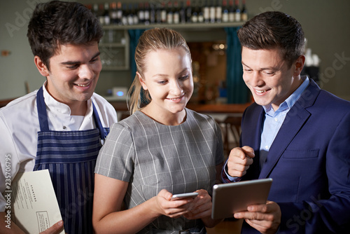 Εκτύπωση καμβά Restaurant Team Discussing Menu Looking At Digital Tablet