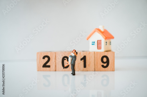 Miniature people, husband and wife hug each other on year 2019 background using as love and family concept