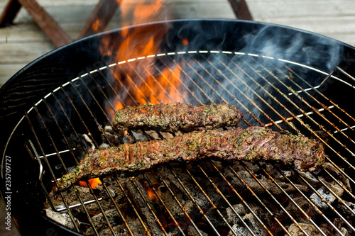 Close up of grilled skirt steak grilling on barbecue grill photo