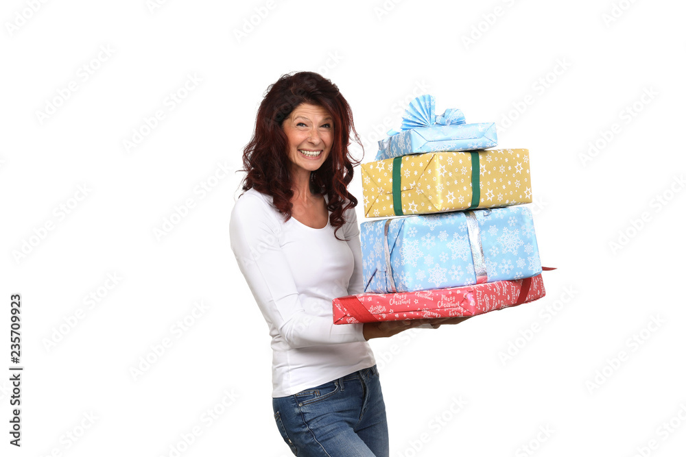 Ältere Frau trägt begeistert Weihnachtsgeschenke Ältere Frau trägt begeistert Weihnachtsgeschenke