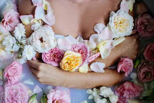 Beautiful girl in the bathroom with many flowers.