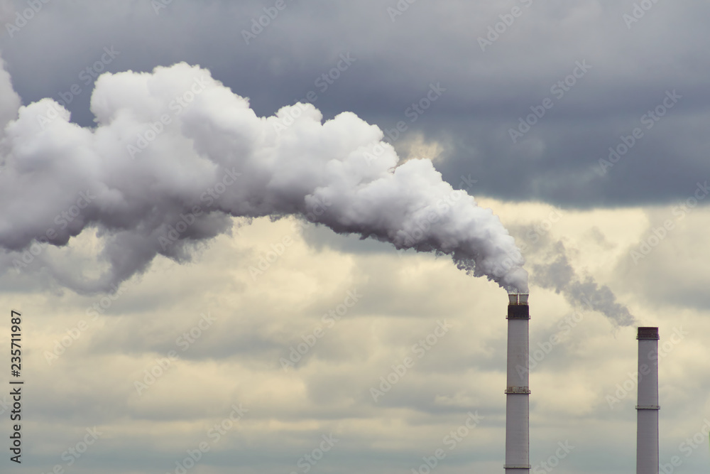 Smoking Industrial Chimneys Of A Power Plant Polluting The Air At Dawn With Grey Clouds. Smoking Industrial Chimneys Of A Power Plant Polluting The Air At Dawn With Grey Clouds.