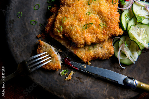 Close up of pork schnitzel served on a plate with pickled veggies photo