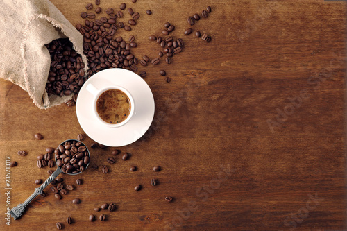 Coffee cup and coffee beans on wooden background. Top view. photo