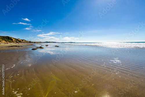 Beautiful deserted empty beach landscape with reflection of the sky on the water. Moeraki Boulders on the Koekohe beach, Eastern coast of Otago, South Island. New Zealand photo