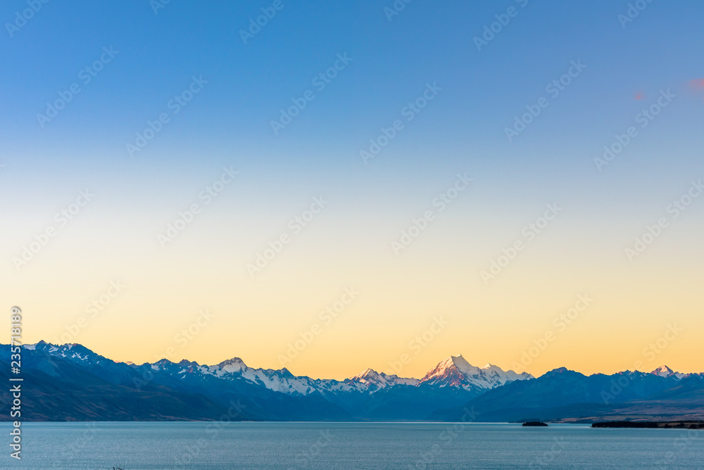 Beautiful landscape view of Mount Cook peak covered in snow at dusk after sunset seen across Lake Pukaki. Aoraki / Mount Cook National Park, New Zealand.