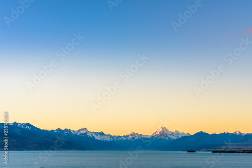 Beautiful landscape view of Mount Cook peak covered in snow at dusk after sunset seen across Lake Pukaki. Aoraki / Mount Cook National Park, New Zealand.
