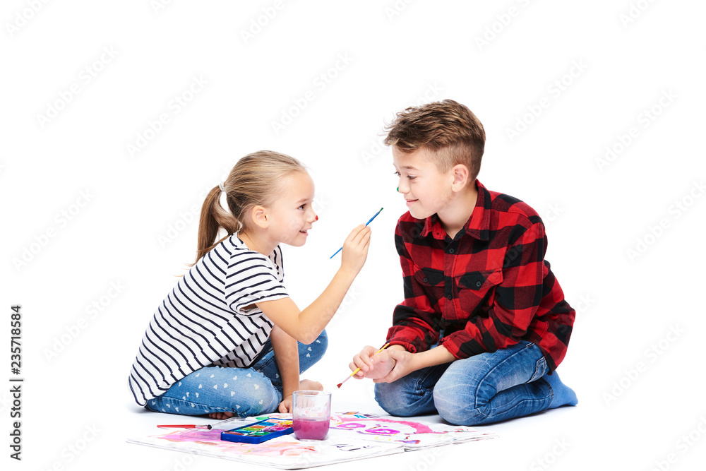 Brother and sister having fun painting with watercolors. Happy creative children at art class. Art therapy concept on white background. Brother and sister having fun painting with watercolors. Happy creative children at art class. Art therapy concept on white background.