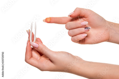 Contact eye lens. Close-up of woman holding white eye lense on finger.