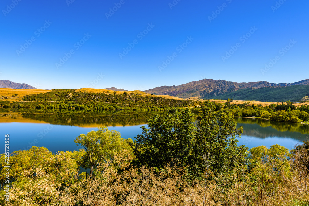Peaceful and calm scene, relaxing hilly and lake landscape. Lake Hayes, Queenstown, New Zealand.