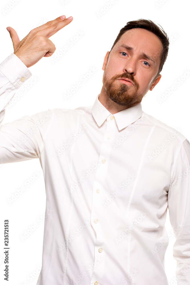 Young man committing suicide with finger gun gesture, shooting himself in head making finger pistol sign, man in white shirt on white background, copy space Young man committing suicide with finger gun gesture, shooting himself in head making finger pistol sign, man in white shirt on white background, copy space