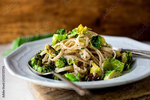 Close up of fettuccine with brussels sprouts, lemon and ricotta served on plate