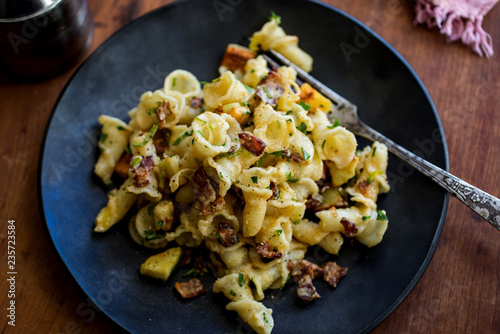 Close up of pasta with parsnip and bacon served on a plate