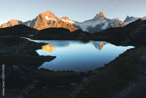 Picturesque view on Bachalpsee lake in Swiss Alps mountains. Snowy peaks of Wetterhorn, Mittelhorn and Rosenhorn on background. Grindelwald valley, Switzerland. Landscape photography