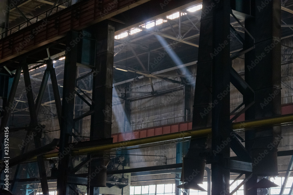 Rays of light in a dark industrial workshop of an industrial plant. Warehouse of heavy iron and metal