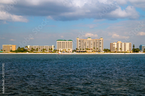 Fort Myers beach Florida holiday vacation destination, coast of Estero Island with beachfront hotel resort buildings, view from the boat