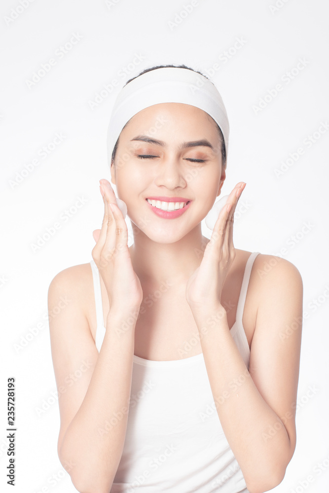 Beautiful woman is washing her face on white background Beautiful woman is washing her face on white background